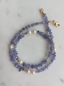 Détail de perles d'eau douce et pierres violettes avec un fermoir doré à 18 carats