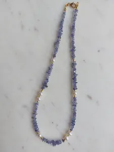Détail du collier plaqué or 18 carats avec pierres violettes et perles blanches