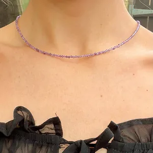 Close-up of minimalist tiny faceted purple natural stone beads necklace on model