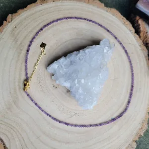 Detailed macro of fine purple natural stone necklace with gold heart charm and crystal