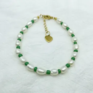 Détail du bracelet en perles d'eau douce avec perles vertes et pendentif cœur doré
