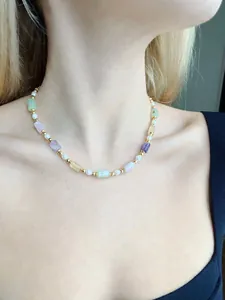 Gros plan d'un collier vintage avec pierres précieuses colorées et perles sur un mannequin