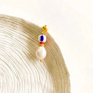 Detail of 18K gold hoop earring with hand-painted bead and Baroque irregular pearl