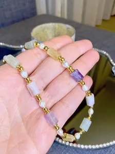 Détail d'un collier vintage avec pierres naturelles, perles d'eau douce et or