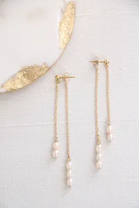 Detailed close-up of vintage long gold tassel earrings with freshwater rice pearls