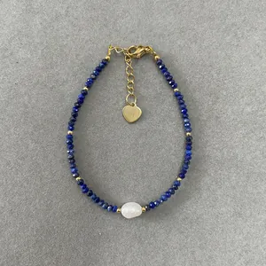 Detail of blue faceted stones bracelet with baroque pearl and golden heart charm
