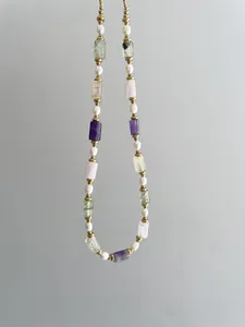 Détail d'un collier bohème avec pierres naturelles, perles d'eau douce et billes dorées