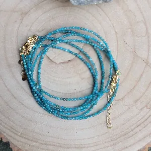 Detailed close-up of blue faceted natural stone beads with gold plated adjustable clasp