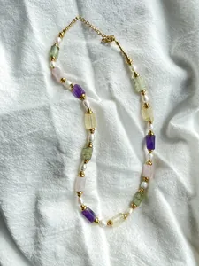Détail d'un collier vintage avec pierres naturelles colorées, perles et fermoir mousqueton doré