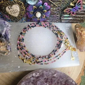 Macro shot of colorful natural stone beads necklace with golden heart charm and crystals