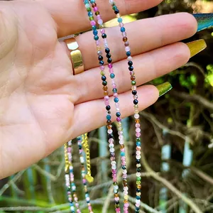 Detailed macro of multi-colored natural stone beaded necklace with gold extension chain