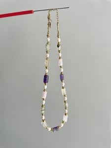 Détail du collier de perles avec pierres colorées et fermoir mousqueton doré