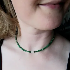 Collier fait main en pierres vertes avec une perle d'eau douce blanche sur modèle