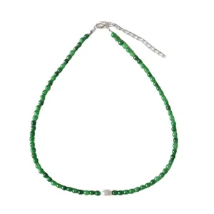 Collier fait main avec perles vert foncé et perle d'eau douce sur fond blanc neutre