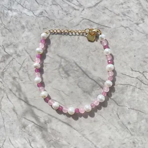 Détail du bracelet en perles d'eau douce avec perles roses et pendentif cœur