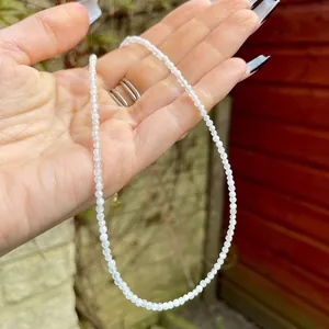 Macro shot of fine faceted white natural stone beads necklace with gold metal clasp