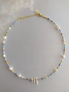 Detail of colorful beads and baroque freshwater pearls necklace with gold lobster clasp
