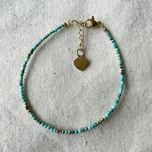Handmade beaded bracelet with turquoise stones, gold spacers and a heart pendant