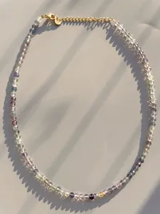 Macro view of colorful natural stone beads with lobster clasp and gold-plated chain