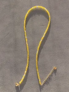 Close-up of yellow faceted natural stone beads with gold plated clasp and extender chain