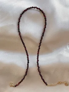 Detail of red faceted natural stone beads with gold plated adjustable chain and lobster clasp