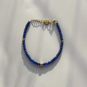 Minimalist dark blue faceted stone bead bracelet with gold accents and a heart charm