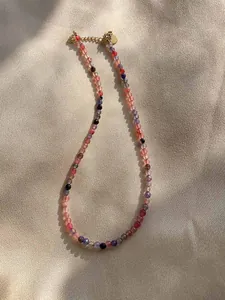 Detail of colorful gemstone beaded necklace with gold heart pendant and lobster clasp