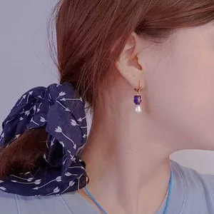 Orecchini a fiore in vetro con perle d'acqua dolce naturali indossati da modella