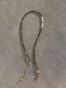 Close-up of black spinel choker necklace with baroque pearls and gold lobster clasp detail