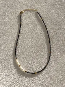 Detail of beaded choker necklace with black spinel, white pearls, and gold clasp
