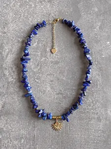 Détail du collier en lapis-lazuli avec pendentif soleil et étiquette en métal en cœur