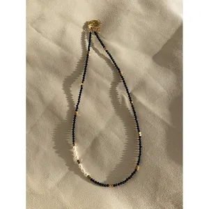 Minimalist black spinel choker necklace featuring freshwater pearls and gold accents