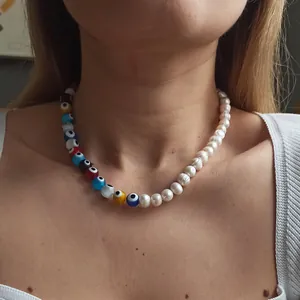 Evil eye beaded necklace with freshwater pearls shown on a female model neck