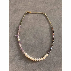 Collier en perles naturelles avec pierres d'améthyste violettes sur tissu texturé
