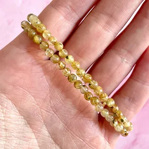 Detailopname van dubbele rekbare armband met natuurlijke gouden rutielkwarts kralen
