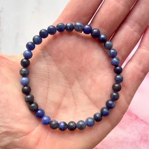 Close-up van elastische armband met donkerblauwe en grijze natuurstenen kralen