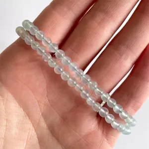 Detail van elastische armbanden met doorschijnende lichtblauwe edelstenen kralen om pols
