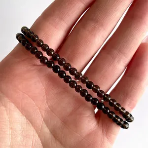 Detail van dubbellaagse armband met rookkwarts kralen op een vrouwelijke pols
