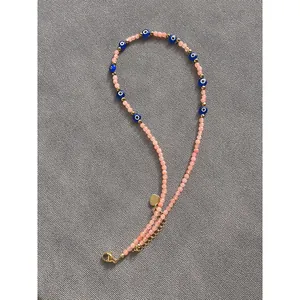 Bohemian beaded necklace featuring pink translucent stones and blue evil eye charms