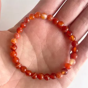 Detailopname van natuurlijke rode agaat kralenarmband met gladde edelsteenstructuur