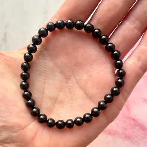 Detailopname van een elastische armband met gepolijste zwarte natuursteen kralen