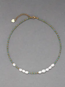 Detail of beaded necklace with gold and blue beads featuring natural baroque pearls