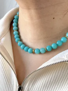 Detail der blauen Naturstein-Perlenkette mit 18k vergoldeten Akzenten am Hals