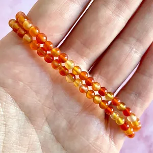 Detailopname van de dubbellaagse elastische armband met doorschijnende oranje agaat kralen