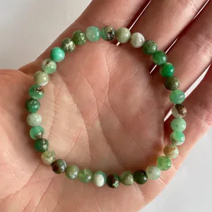 Detailweergave van een elastische armband met groene natuursteen kralen op hand