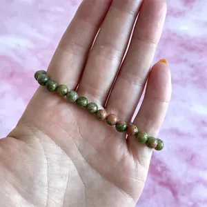 Detailopname van een natuurlijke Unakite kralenarmband met groen-roze texturen