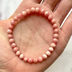 Detailopname van een rekbare armband van roze rhodochrosiet kralen met natuurlijke textuur