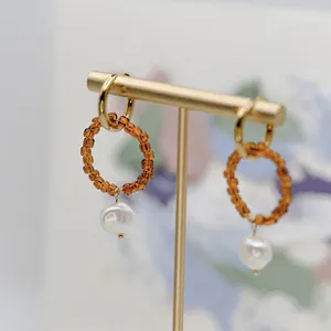 Créoles dorées avec perles ambrées et perle d'eau douce blanche sur support de bijoux