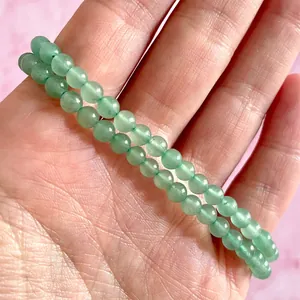 Detail van twee lichtgroene natuurstenen kralenarmbanden met 6mm gladde kralen om de pols