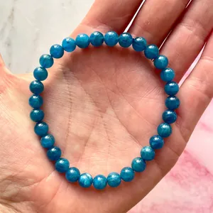 Detailopname van de 6-8mm blauwe apatiet edelsteen kralenarmband om de vrouwelijke pols